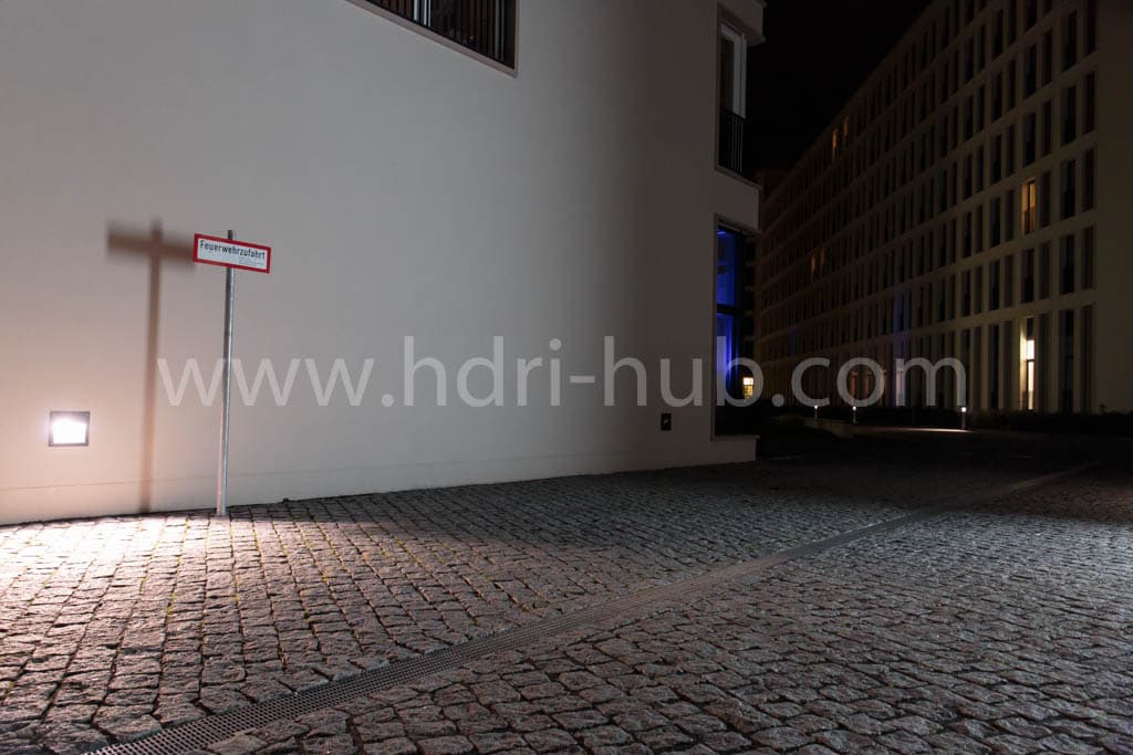 Night backplate from HDR 138 City Night Place: cobblestone square lit by a wall lamp next to a modern office building
